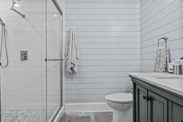 bathroom featuring vanity, toilet, and a shower with shower door