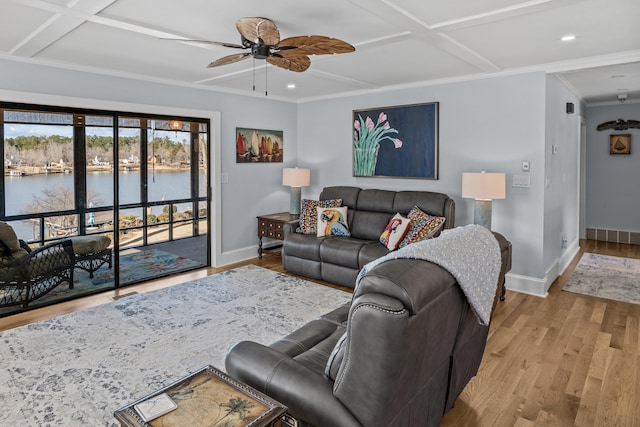 living room featuring ornamental molding, coffered ceiling, ceiling fan, a water view, and light wood-type flooring