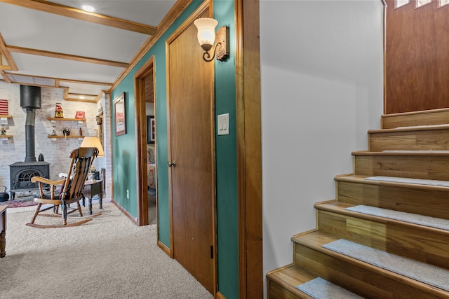 stairs with a wood stove, brick wall, and carpet