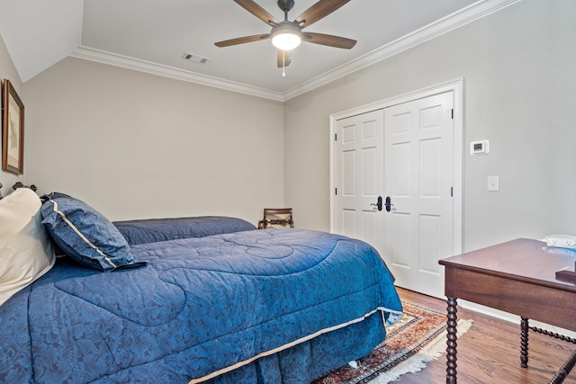 bedroom with hardwood / wood-style floors, crown molding, a closet, and ceiling fan