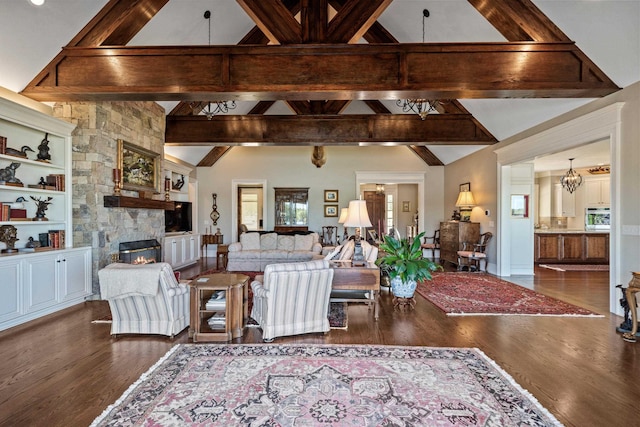 living room featuring an inviting chandelier, a stone fireplace, dark hardwood / wood-style flooring, and lofted ceiling with beams