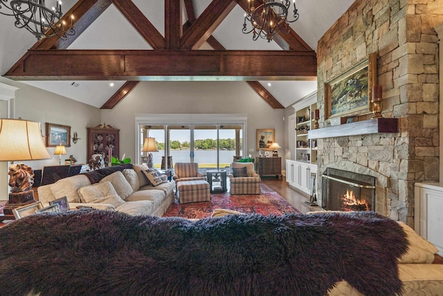 living room with hardwood / wood-style flooring, beam ceiling, high vaulted ceiling, a stone fireplace, and a chandelier