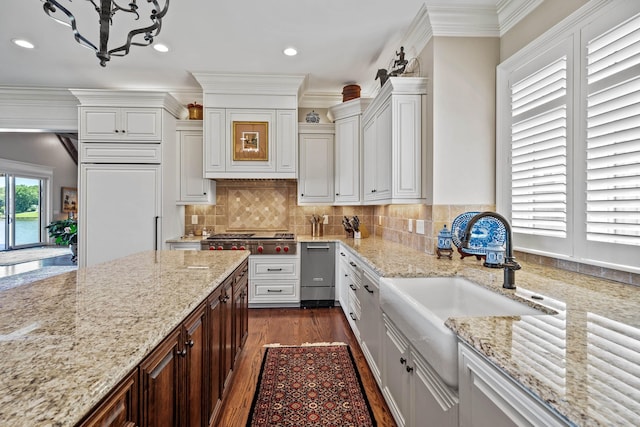 kitchen with light stone counters, crown molding, dark hardwood / wood-style flooring, and tasteful backsplash