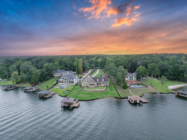 aerial view at dusk featuring a water view