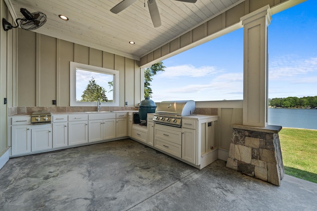 view of patio featuring sink, ceiling fan, a water view, grilling area, and an outdoor kitchen