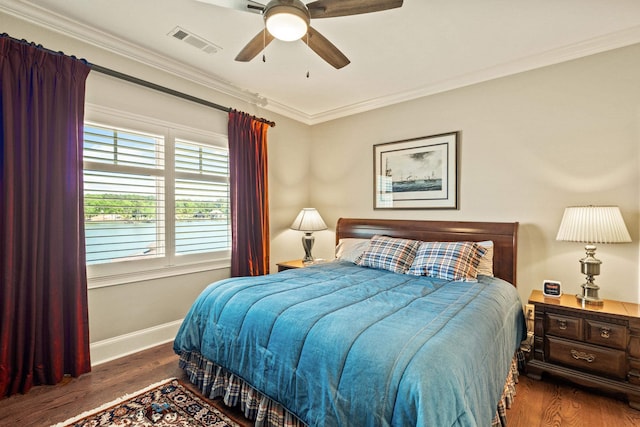 bedroom featuring ceiling fan, ornamental molding, and dark hardwood / wood-style flooring