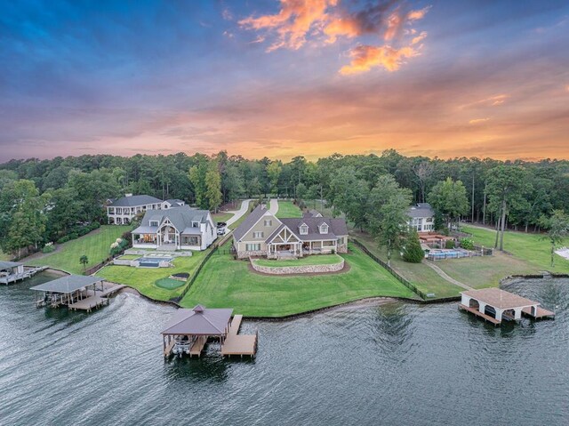 aerial view at dusk featuring a water view