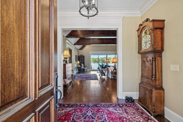 entryway with crown molding, wood-type flooring, and a chandelier