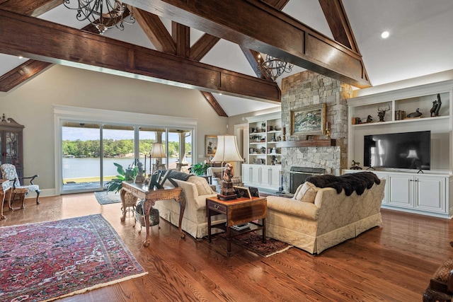 living room with a stone fireplace, a water view, dark hardwood / wood-style flooring, built in features, and beam ceiling