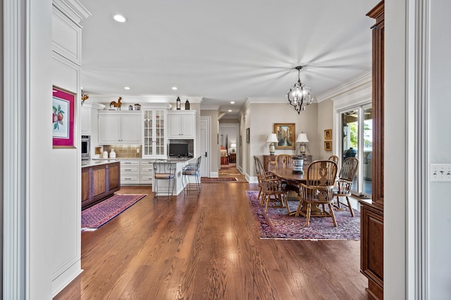 dining room featuring crown molding, hardwood / wood-style floors, and an inviting chandelier