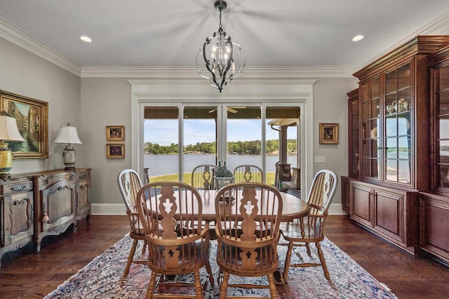 dining space with a water view, ornamental molding, dark hardwood / wood-style flooring, and a chandelier