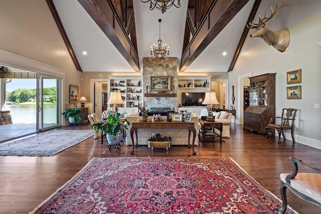 living room featuring high vaulted ceiling, a notable chandelier, dark hardwood / wood-style flooring, a stone fireplace, and beamed ceiling