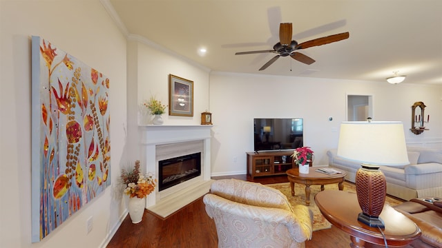 living room with wood-type flooring, ornamental molding, and ceiling fan