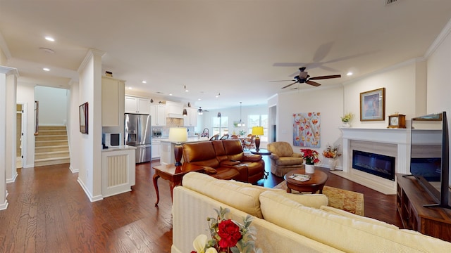 living room featuring ornamental molding, ceiling fan, and dark hardwood / wood-style flooring