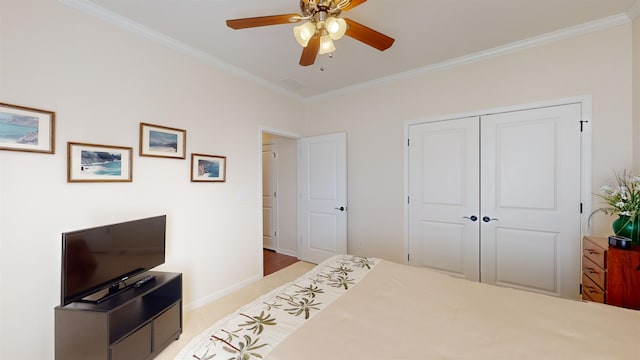 bedroom featuring crown molding, light carpet, ceiling fan, and a closet