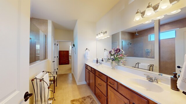 bathroom featuring tiled shower and vanity