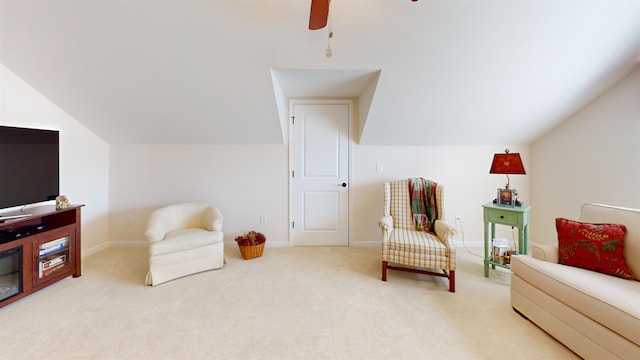 sitting room with ceiling fan, lofted ceiling, and light carpet