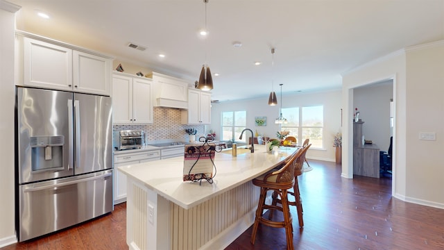 kitchen featuring white cabinetry, an island with sink, decorative light fixtures, and stainless steel fridge with ice dispenser