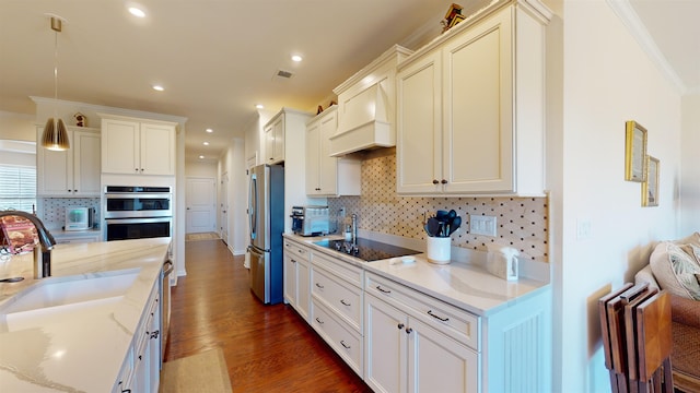 kitchen with premium range hood, light stone counters, tasteful backsplash, appliances with stainless steel finishes, and dark hardwood / wood-style floors