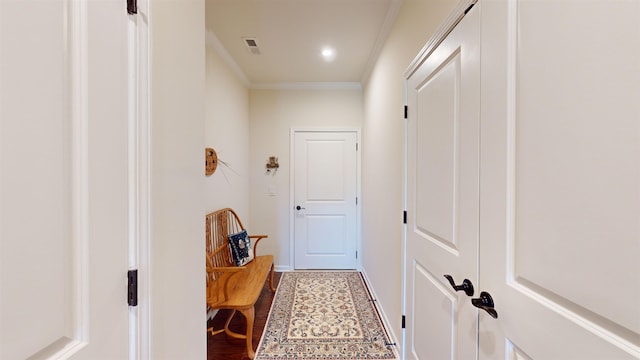 corridor with ornamental molding and hardwood / wood-style floors