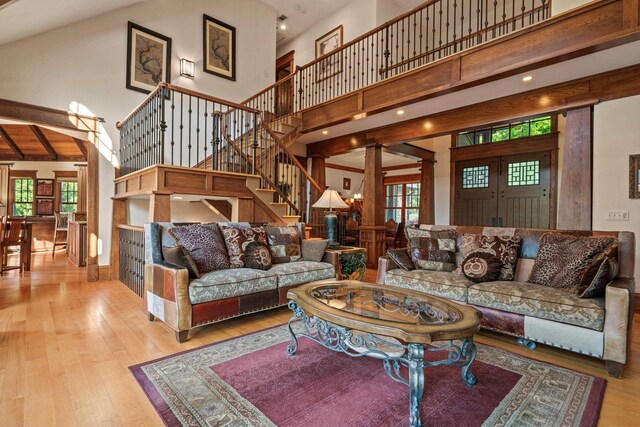 1611 Pine Grove Rd, Greensboro, GA 30642 - living room featuring a high ceiling, ornate columns, light wood-type flooring, and beam ceiling