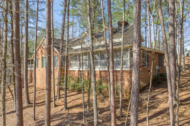 exterior space featuring brick siding and a sunroom