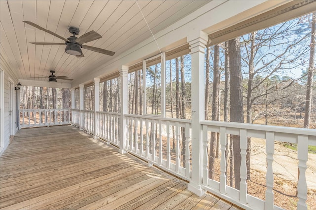 unfurnished sunroom with wood ceiling and a ceiling fan