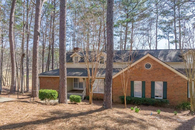 view of front of property featuring brick siding and a chimney