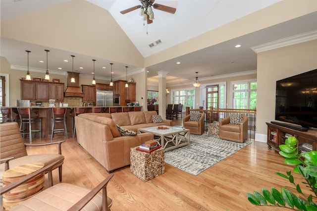 1051 Swift Crk, Greensboro, GA 30642 - living room with light wood-type flooring, ceiling fan, ornate columns, vaulted ceiling, and ornamental molding