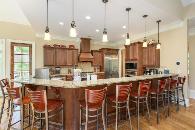 1051 Swift Crk, Greensboro, GA 30642 - kitchen with premium range hood, built in appliances, decorative backsplash, a peninsula, and brown cabinetry