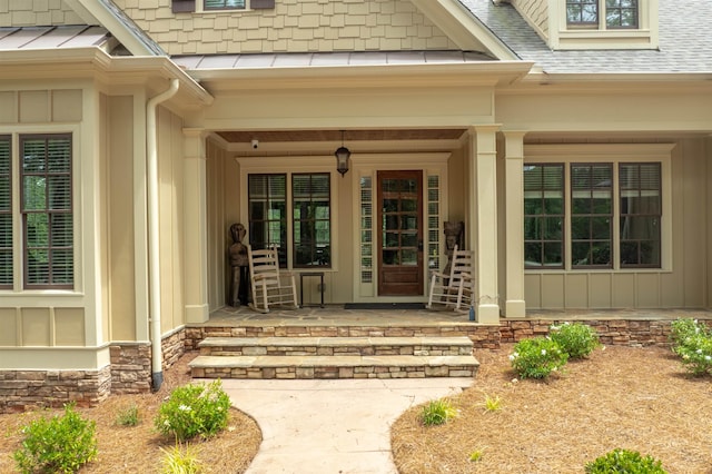 1051 Swift Crk, Greensboro, GA 30642 - entrance to property with covered porch, a standing seam roof, roof with shingles, stone siding, and metal roof