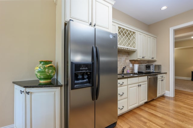 1051 Swift Crk, Greensboro, GA 30642 - kitchen with appliances with stainless steel finishes, a sink, backsplash, light wood-style flooring, and baseboards
