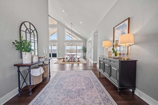 interior space featuring baseboards, high vaulted ceiling, and dark wood-type flooring