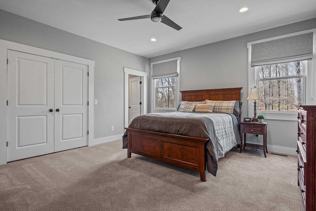 bedroom featuring recessed lighting, a closet, light carpet, and baseboards