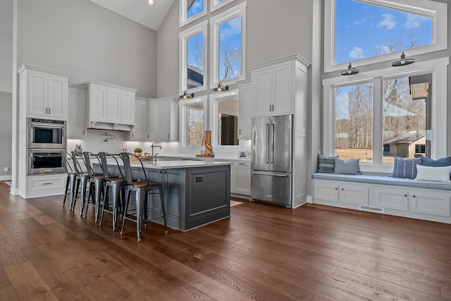 kitchen with appliances with stainless steel finishes, visible vents, dark wood finished floors, and white cabinetry