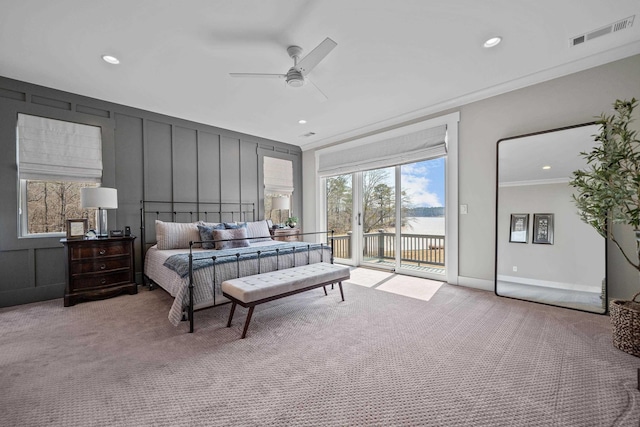 bedroom with crown molding, visible vents, a decorative wall, light carpet, and access to outside