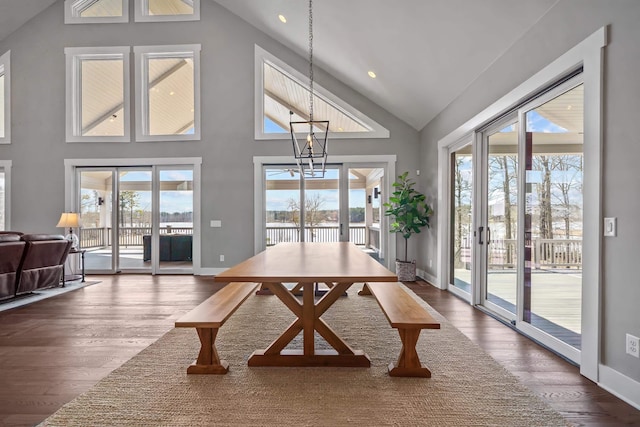 dining space with dark wood-style floors, an inviting chandelier, a wealth of natural light, and baseboards