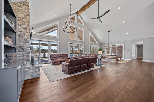 living area with dark wood-style floors, beam ceiling, high vaulted ceiling, baseboards, and ceiling fan with notable chandelier