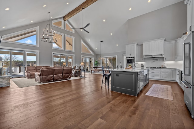 kitchen with dark wood finished floors, a notable chandelier, light countertops, open floor plan, and a kitchen breakfast bar