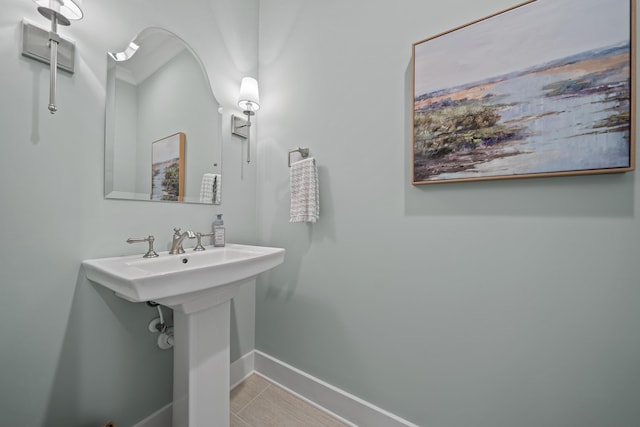 bathroom featuring tile patterned flooring, a sink, and baseboards