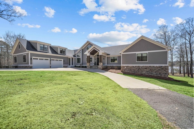 view of front facade with concrete driveway, a front lawn, and stone siding