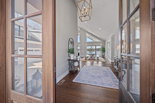 entryway with high vaulted ceiling, dark wood finished floors, visible vents, and a notable chandelier