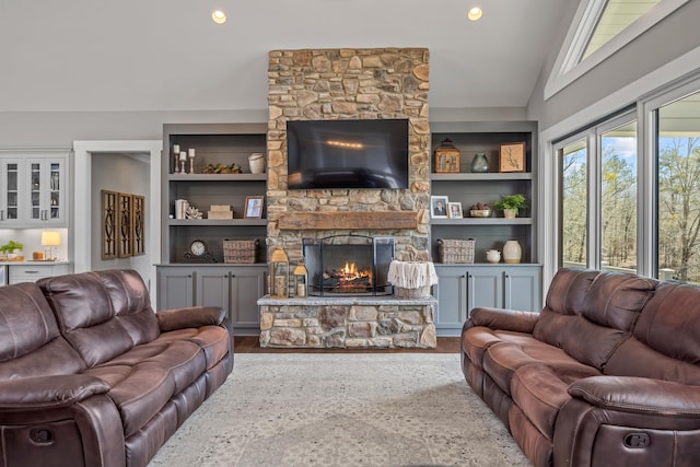 living area with lofted ceiling, built in shelves, recessed lighting, a fireplace, and wood finished floors