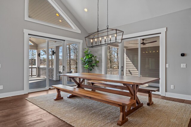 dining room with high vaulted ceiling, baseboards, wood finished floors, and recessed lighting