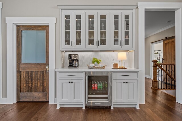 bar with crown molding, wine cooler, dark wood-style flooring, and tasteful backsplash