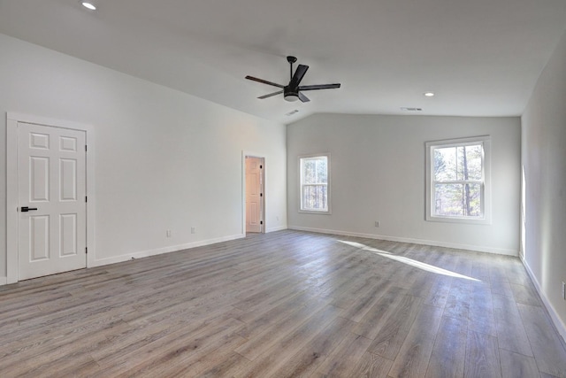 empty room with light hardwood / wood-style flooring, a wealth of natural light, lofted ceiling, and ceiling fan