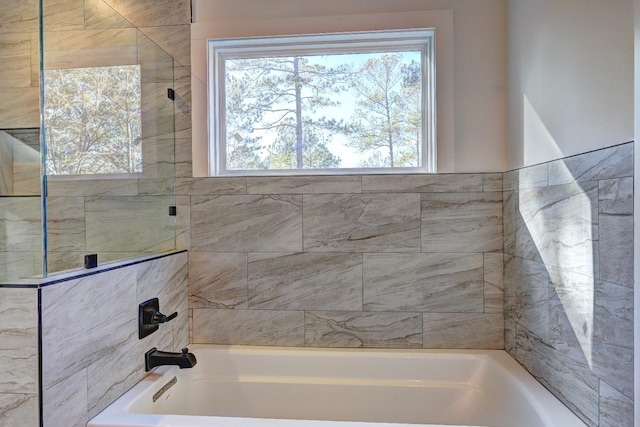 bathroom featuring independent shower and bath