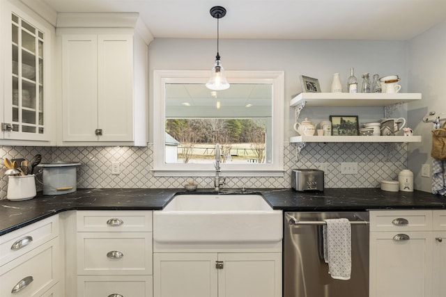 kitchen featuring decorative light fixtures, stainless steel dishwasher, glass insert cabinets, white cabinets, and a sink