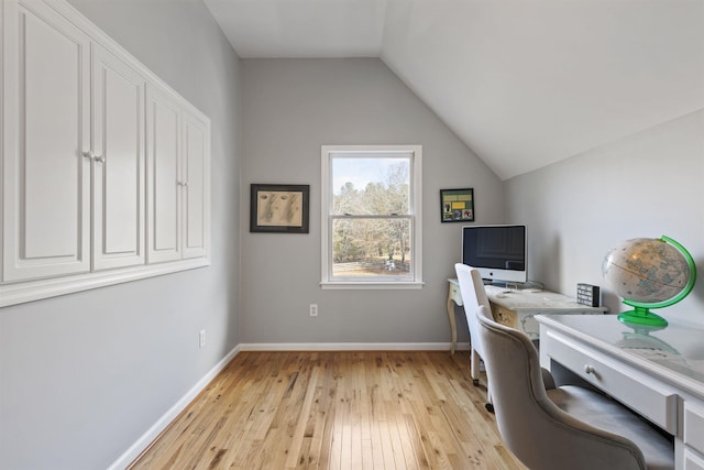 home office featuring baseboards, vaulted ceiling, and light wood finished floors