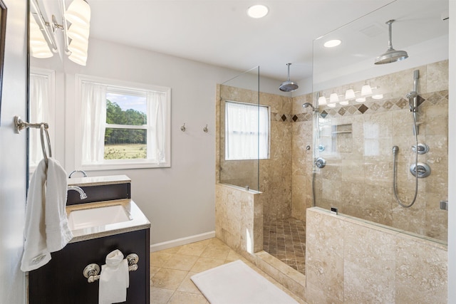 bathroom featuring tile patterned flooring, a healthy amount of sunlight, baseboards, and a walk in shower